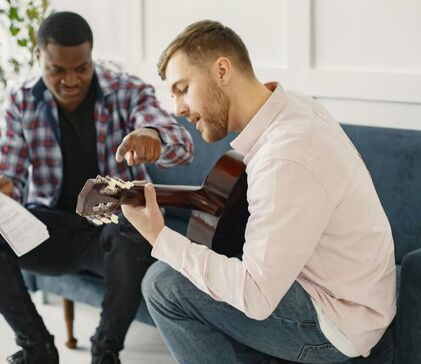 Picture of an adult guitar lesson. We show this picture because we offer adult guitar lessons. Currently a high percentage of our students are adult musicians.